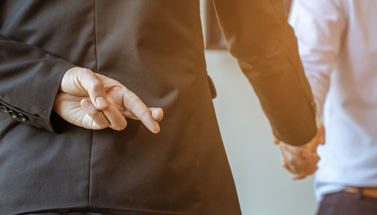 Betrayal partners pretend to shake hands to make a deal, It is a picture of the working atmosphere of company employees in the office in the early 21st century.